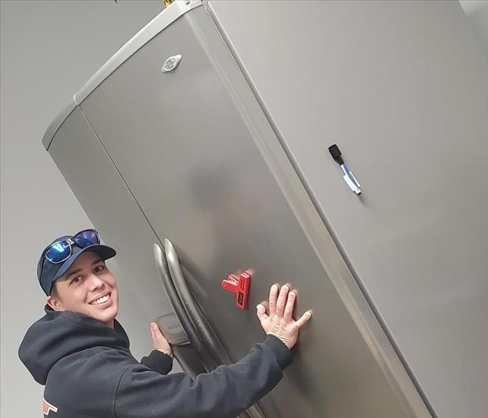 Going the extra mile - image of person touching fridge